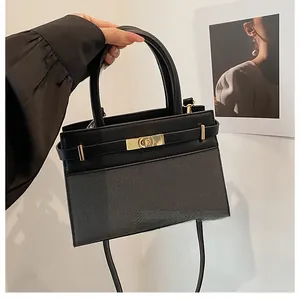 Detail view of the black and gray textured fabric handbag with golden twist lock