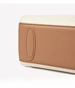 Gros plan d'un sac cabas en cuir contrasté avec panneaux beiges et coutures soignées