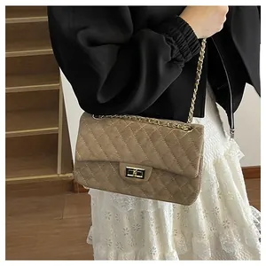 Detail of velvet quilted shoulder bag with gold chain strap and turn-lock closure