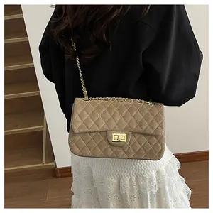 Detail of khaki velvet crossbody bag showing diamond quilting and metal chain strap