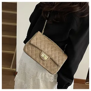 Detail of khaki quilted velvet bag with gold chain strap and rotary lock on model