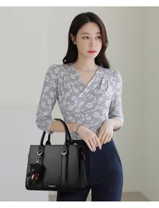 Détail du sac à main en cuir grainé noir avec lettrage doré et charm d'ours mignon