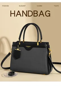 Detail einer eleganten zweifarbigen Handtasche mit goldenen Beschlägen und Logo
