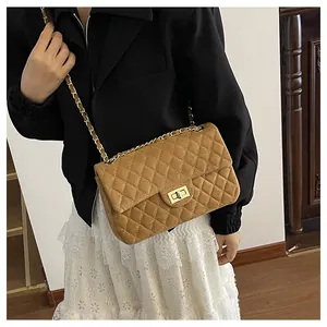 Close-up of brown velvet quilted handbag with gold chain strap and turn-lock closure