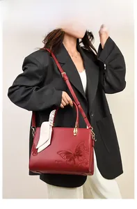 Mannequin portant un sac cabas rouge avec gaufrage floral et écharpe en soie décorative
