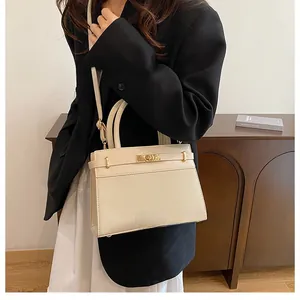 Side view of a beige woven texture handbag with golden clasp and adjustable strap