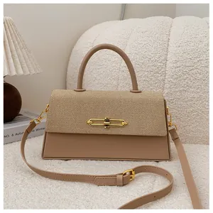 Detail der khakifarbenen Handtasche mit Webtextur und goldenem Ringverschluss