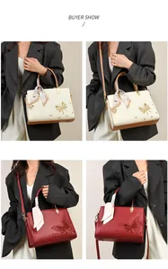 Détail d'un cabas brodé avec motifs floraux et foulard enroulé sur la poignée