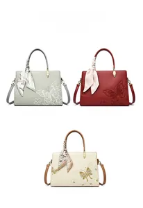 Trois sacs cabas brodés en gris, rouge et blanc avec des foulards élégants en soie