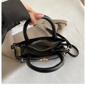 Interior layout of black dual-handle bag with three compartments and golden hardware
