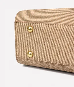 Detailansicht des beigen Stofftaschenbodens mit schützenden goldenen Metall-Bodenfüßen