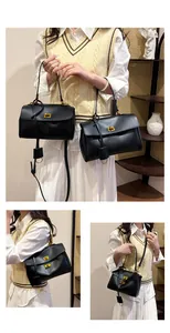 Detail showing high-quality black leather tote bags with elegant gold twist lock and strap