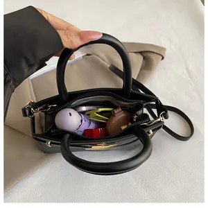 Top view showing the large capacity interior of a black leather handbag with daily essentials