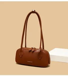 Dettaglio della borsa baguette marrone in pelle martellata con logo e doppi spallacci