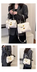 Detail showing two sizes of white vintage tote bags with golden twist-lock and slim straps