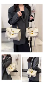 Detail view of cream shoulder bags in two sizes with gold turn-lock and leather texture