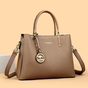 Elegante bolso de mano para mujer en cuero granulado beige con detalles metálicos dorados