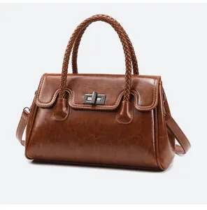 Détail du sac cabas en cuir huilé marron avec poignée tressée et fermoir pivotant