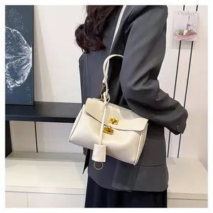 Detailed view of creamy white tote bag with gold twist lock and fine lychee texture