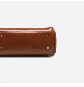 Vue détaillée du fond du sac en cuir huilé marron avec quatre clous de protection en métal