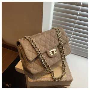 Detail of velvet quilted shoulder bag with golden chain strap and rectangular clasp