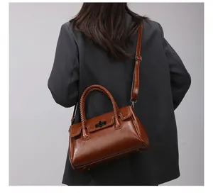 Sac cabas marron en cuir ciré avec poignées tressées et fermoir en métal sur modèle