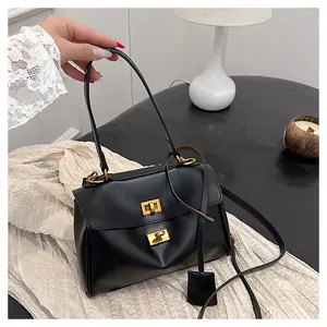 Close-up of black retro tote bag with dual gold twist locks and leather texture details