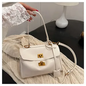 Detail of white matte faux leather handbag with gold twist lock and adjustable strap