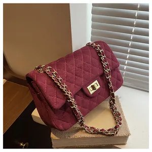 Detailed view of quilted velvet texture and gold metal clasp on burgundy crossbody bag