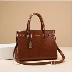 Detail view of brown vintage PU leather texture with gold brand logo and metal rivets