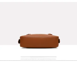 Dettaglio della pelle marrone a grana litchi e delle cuciture sul fondo della borsa