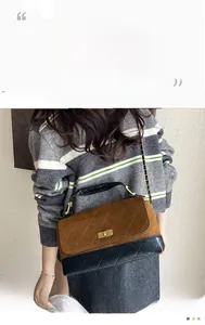 Close-up of matte quilted crossbody bag featuring contrasting leather and metal chain strap