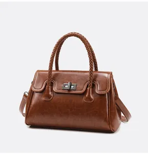 Vue détaillée du sac en similicuir marron avec poignées tressées et fermoir pivotant