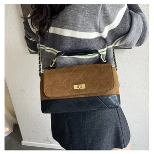 Detail of contrast color quilted shoulder bag with gold turn-lock and chain strap
