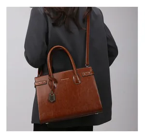 Brown vintage faux leather handbag on model showing scale and elegant styling
