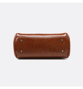 Détails de la base du sac cabas marron avec pieds en métal et texture en cuir ciré à l'huile