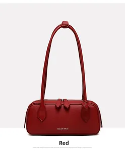 Dettaglio borsa rossa in pelle a grana di litchi con doppia cerniera e logo del brand