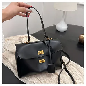 Detail of black matte leather handbag featuring iconic golden twist-lock buckles