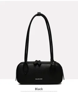 Dettaglio della pelle nera a grana di litchi e logo del marchio su borsa baguette