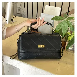 Detail of black quilted leather texture and gold metal twist lock on a vintage handbag