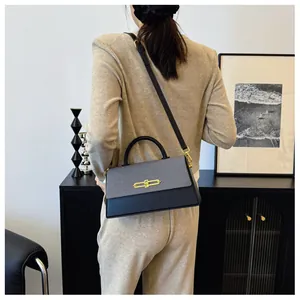 Detailansicht der Kontraststruktur aus schwarzem Leder und grauem Webstoff an der Handtasche