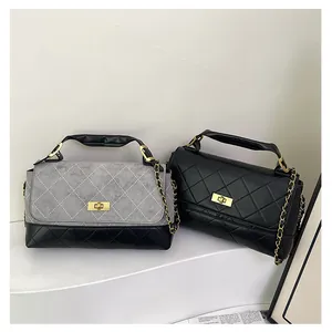 Detail of matte quilted bucket bags with contrast stitching and gold chain straps