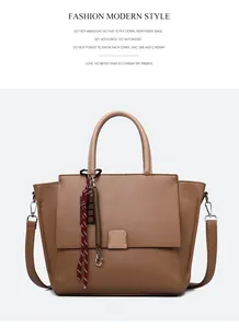 Detail van de bruine tote bag met lychee-textuur en gestreepte hanger met handvat