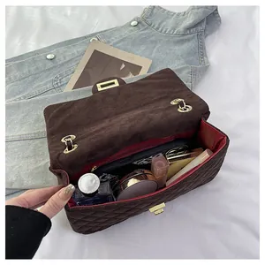 Detail of velvet quilted flap bag showing red lining and spacious interior storage