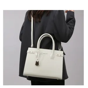 Model wearing white lychee leather tote bag with FASHION & BAGS logo and shoulder strap