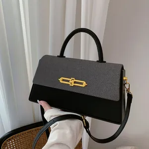 Detail der Crossbody-Tasche in Kontrastfarben mit goldener Schnalle und Webstruktur