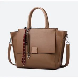 Detail van vintage bruine leren tote bag met gevlochten koord accessoire