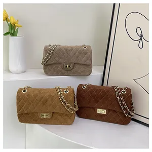 Detailed view of three quilted velvet crossbody bags in khaki and brown tones