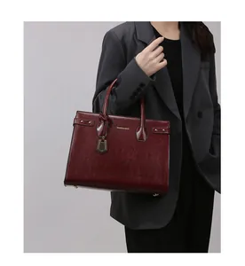 Close-up of a burgundy vintage leather handbag with marbled texture and gold logo details