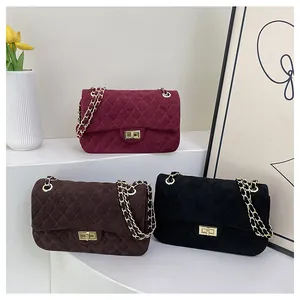 Close-up of quilted velvet crossbody bags in burgundy, coffee, and black with gold chains